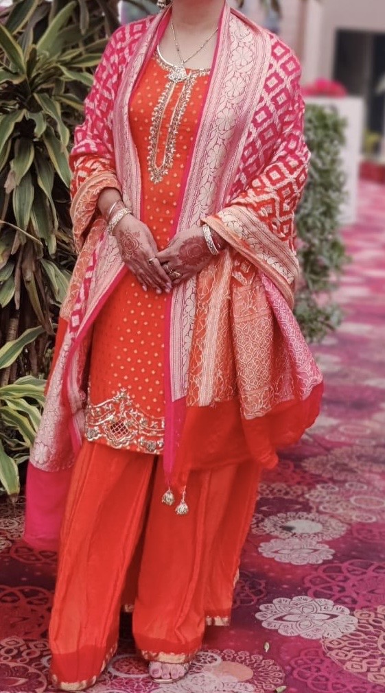 Orange dotted kameez with a pink banarasi shawl and matching pants